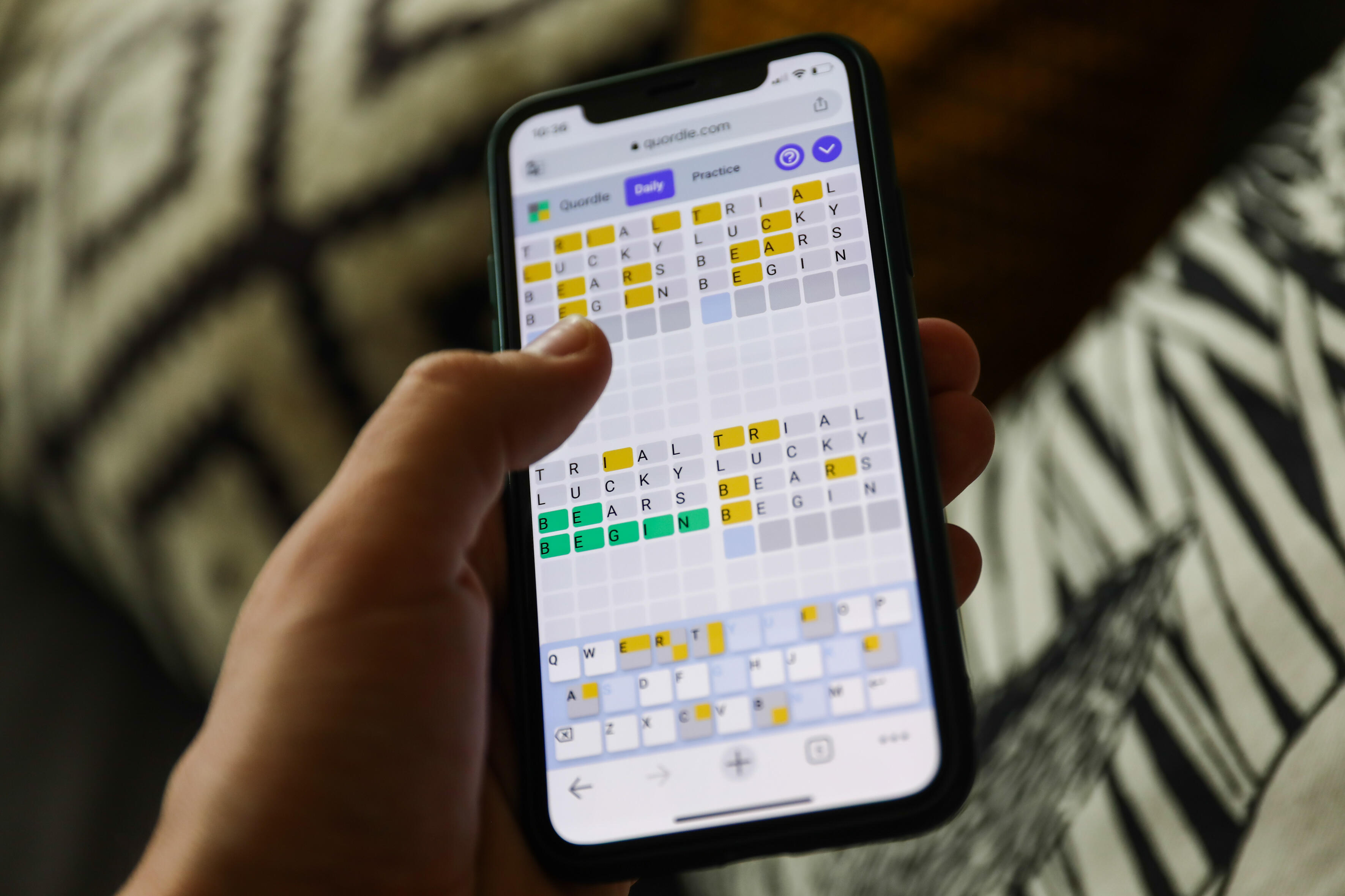 A person playing Quordle on their phone.