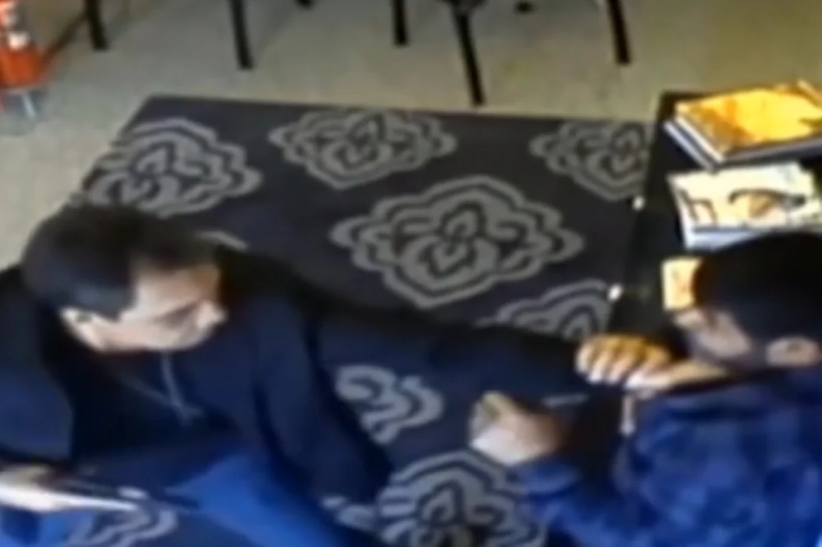 Imagem colorida de policial civil apontando arma para comerciante iraniano. Metrópoles