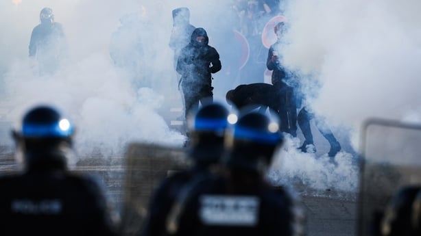 Police officers stand in front of protestors amid tear gas as protesting students carry out blockading action near the Kerichen high school in Brest, western France