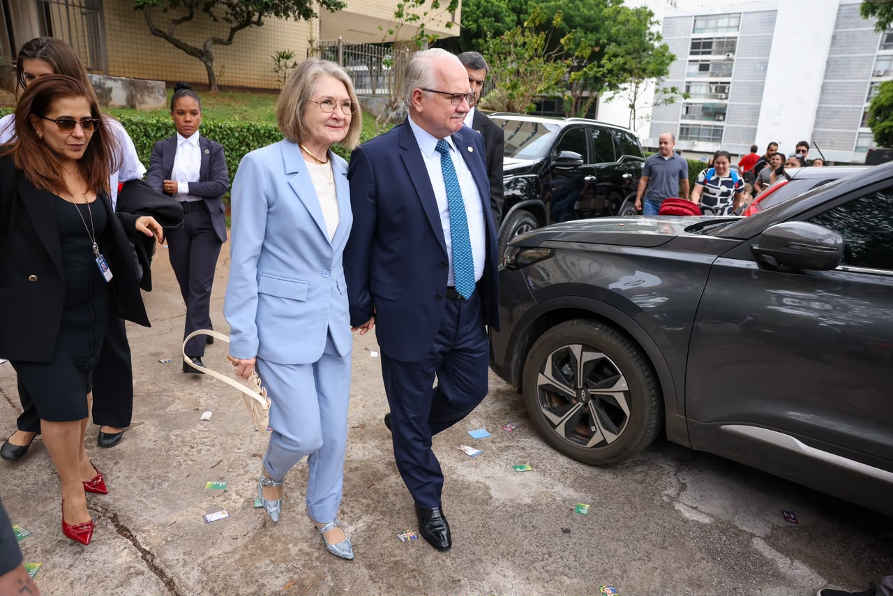 Presidente do STF chegando para votar e conversando com voluntária da Justiça Eleitoral enquanto espera na fila