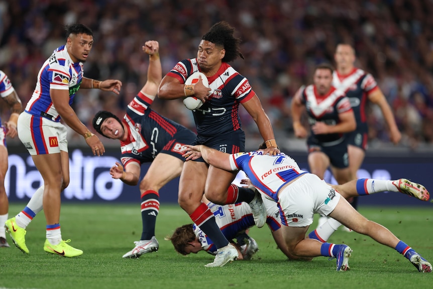 A man runs the ball during a rugby league match