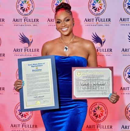 Beaming with pride, model Camille McDonald shows off the proclamation she received from New York State Senator Kevin Parker for her service to humanity at the 16th annual Arit Fuller Foundation Gala Dinner in Manhattan on Saturday, September 26, 2026.